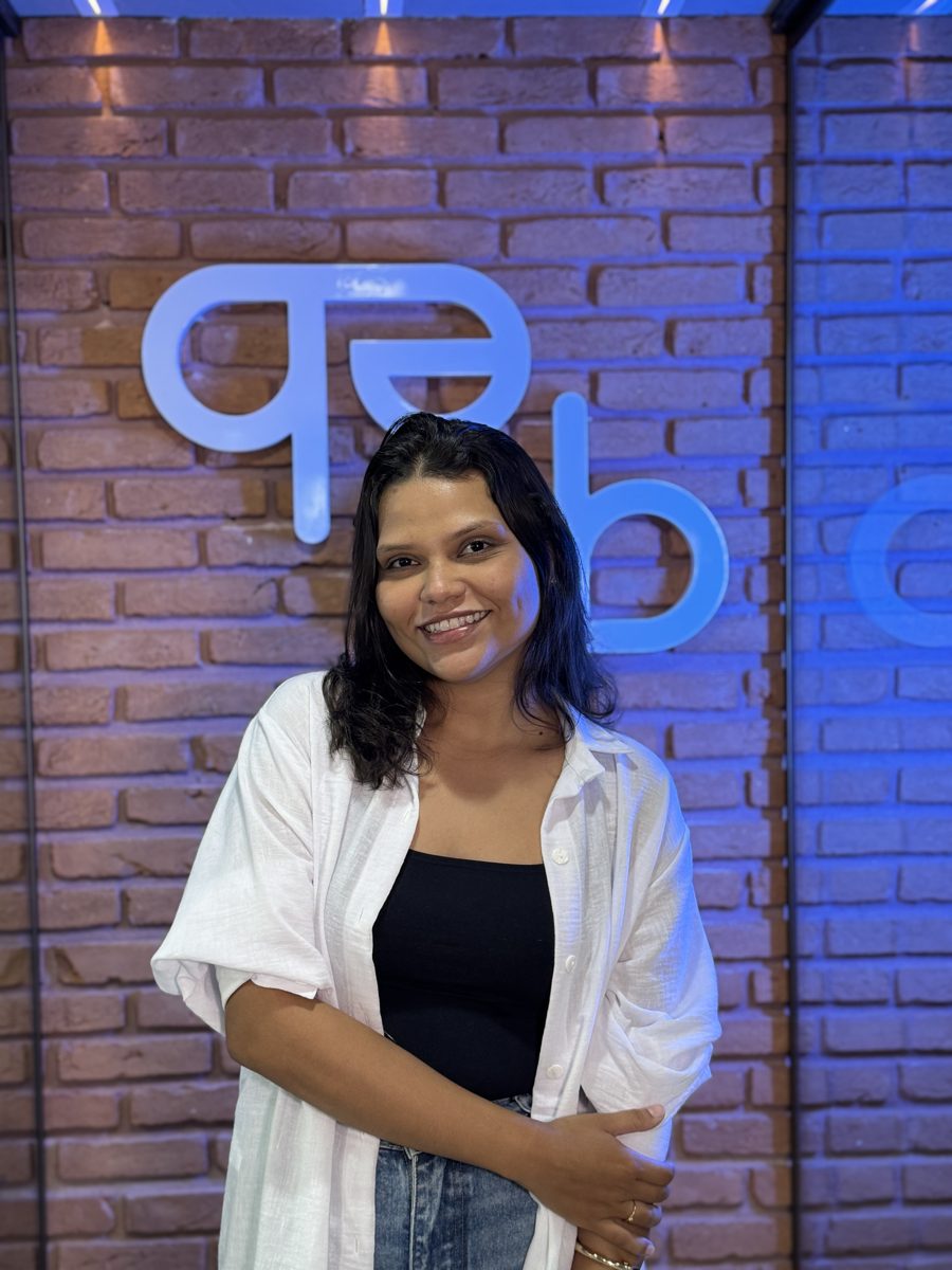 Raquel Freitas em frente ao logo da ebrand